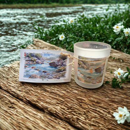 Bougie artisanale du Sud-Ouest Candèras Gave avec carte postale assortie sur fond minéral clair.
