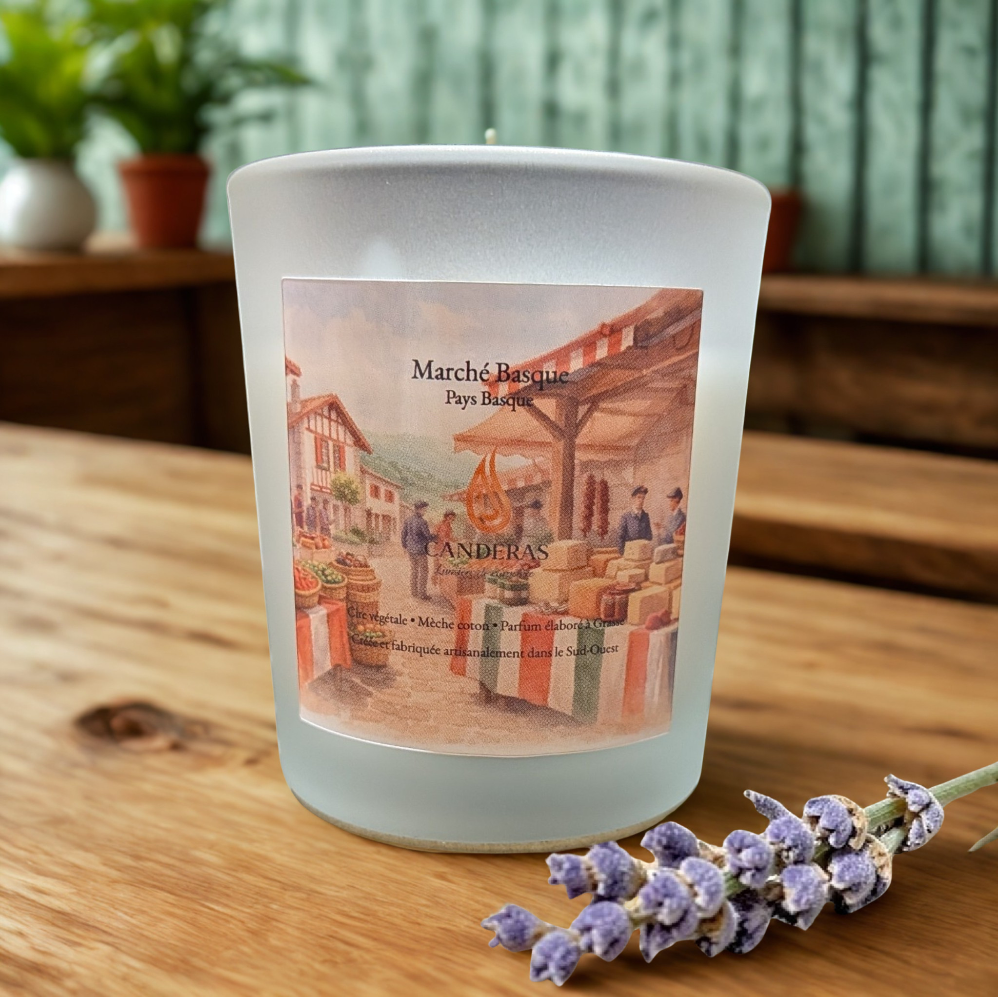 Bougie artisanale du Sud-Ouest Candèras Marché basque en verre givré sur fond bois clair et mur texturé.