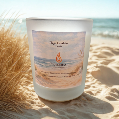 Bougie artisanale du Sud-Ouest Candèras Plage landaise en verre givré sur fond bois clair et mur texturé.